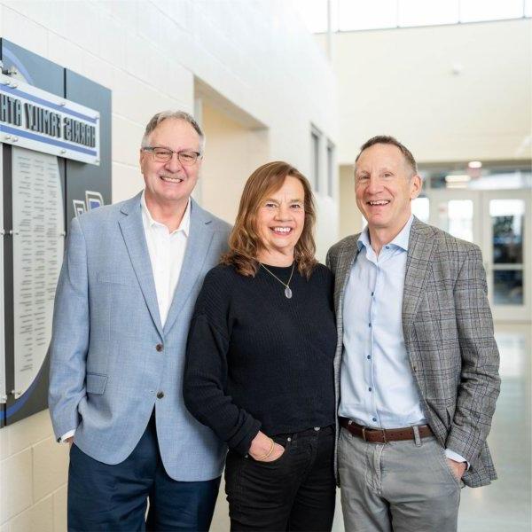 three people standing near hall of fame wall in the Fieldhouse